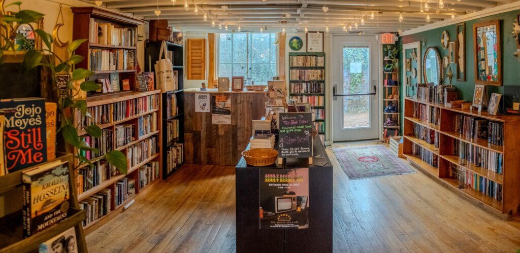 A wide view of the interior of The Book Cellar, showcasing bookshelves filled with books and a variety of items for sale.