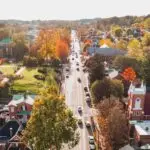 Aerial view of Main Street in downtown Abingdon, Virginia, surrounded by colorful fall foliage, historic buildings, and tree-lined neighborhoods.